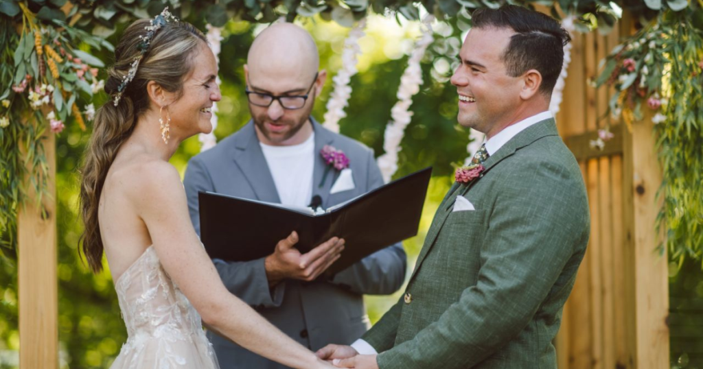 Wedding photo of a bride and groom with their officiant during their ceremony