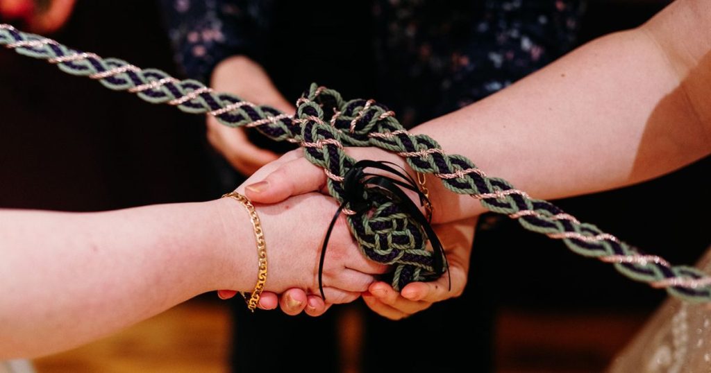 Two hands wrapped in a cord as part of a DC Pinstripes wedding ceremony