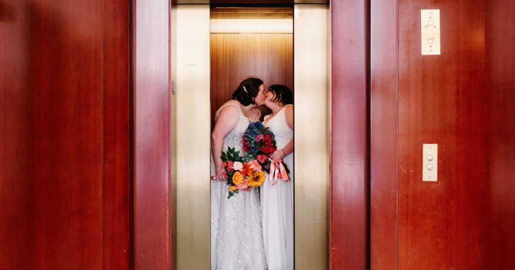 Brides sharing a kiss in the elevator at the Ritz-Carlton Georgetown before their DC Pinstripes wedding