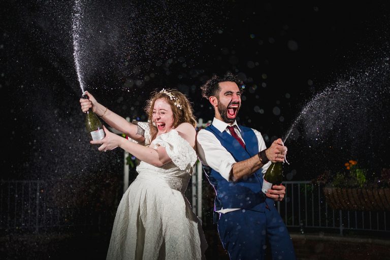 Newlywed couple sprays champagne