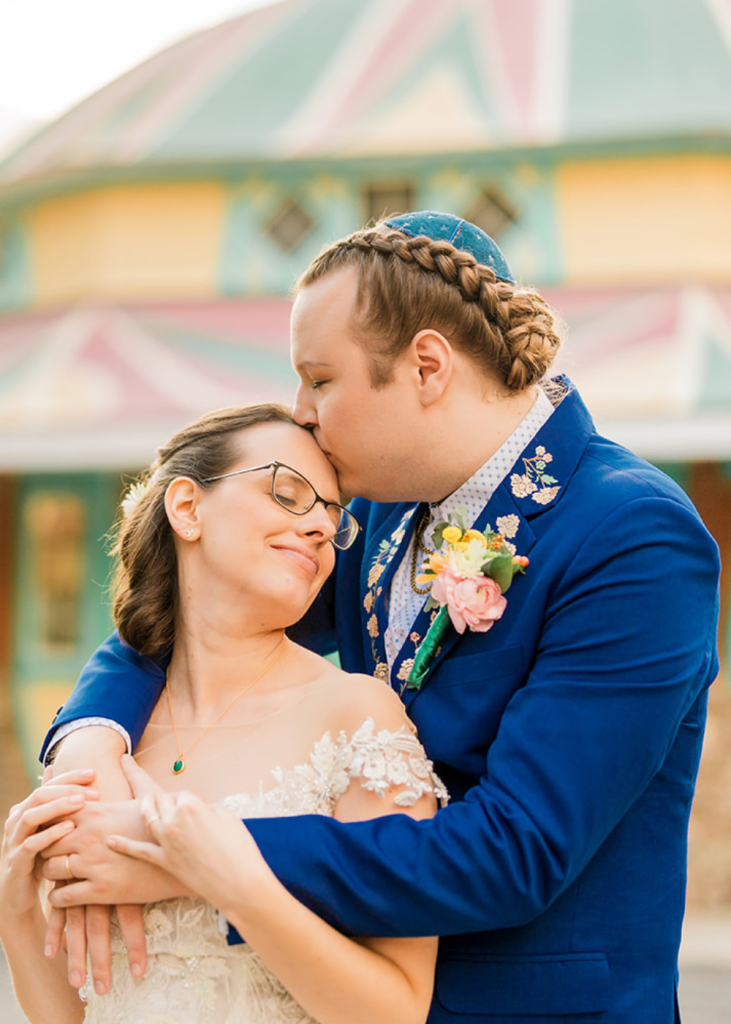 a newlywed couple embraces at Glen Echo Park