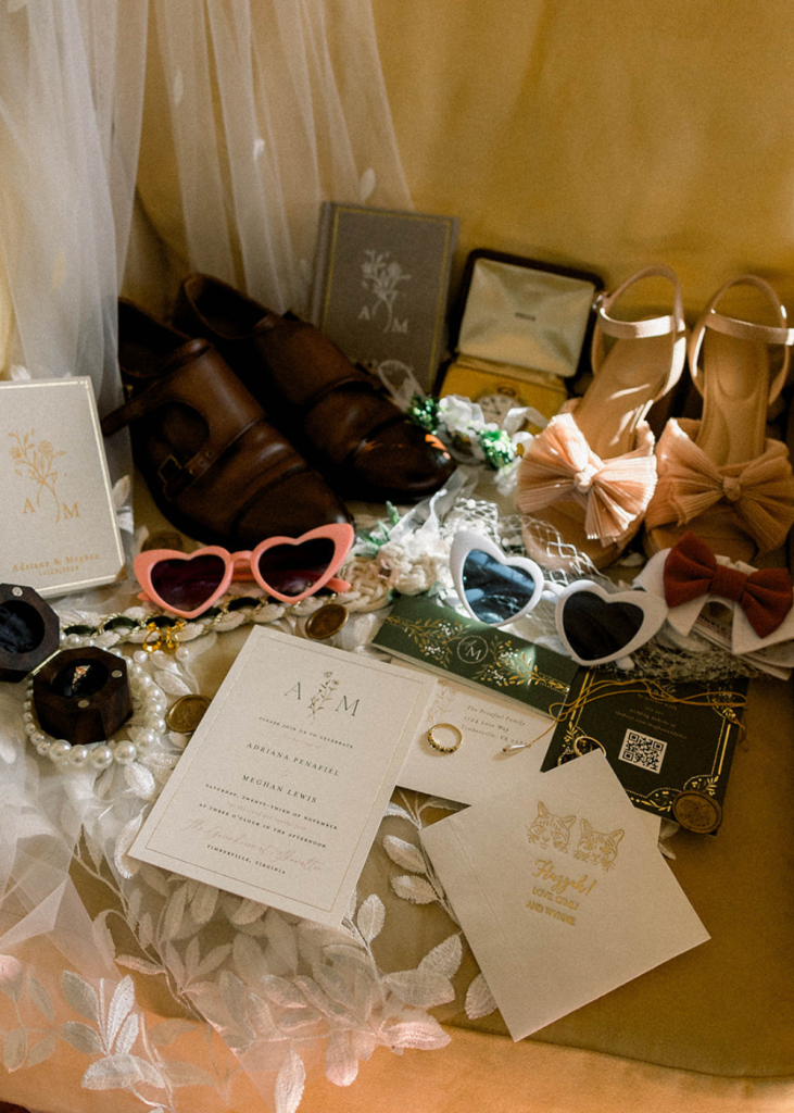 a photo of wedding items including the couple's shoes, sunglasses, invitation, and cocktail hour napkin