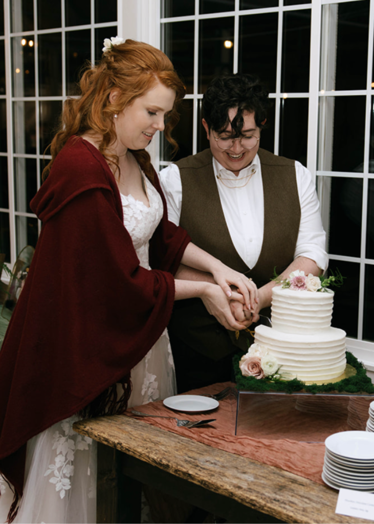 newlyweds cut their wedding cake together