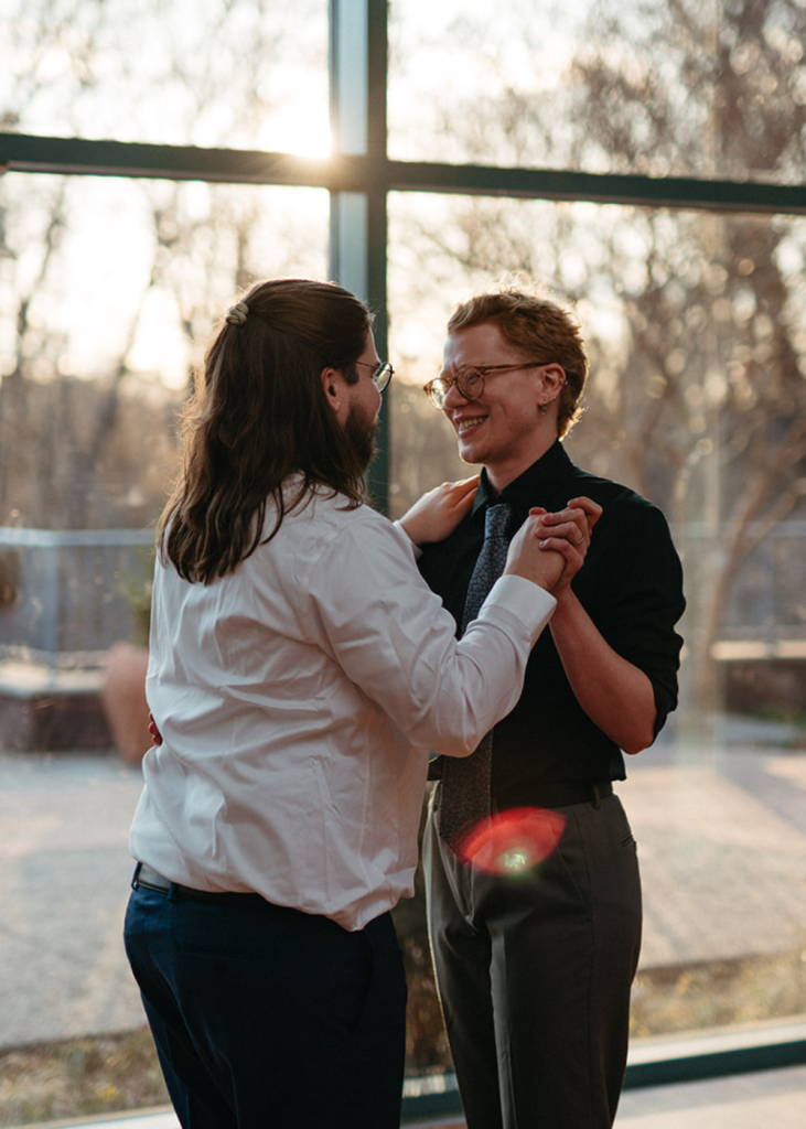 a couple shares their first dance and holds hands at the atrium at meadowlark botanical gardens