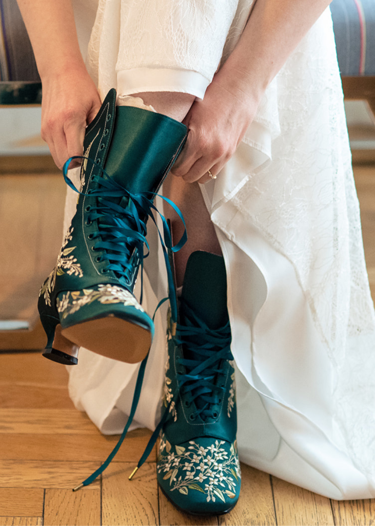 a spouse puts on their green boots before the wedding ceremony