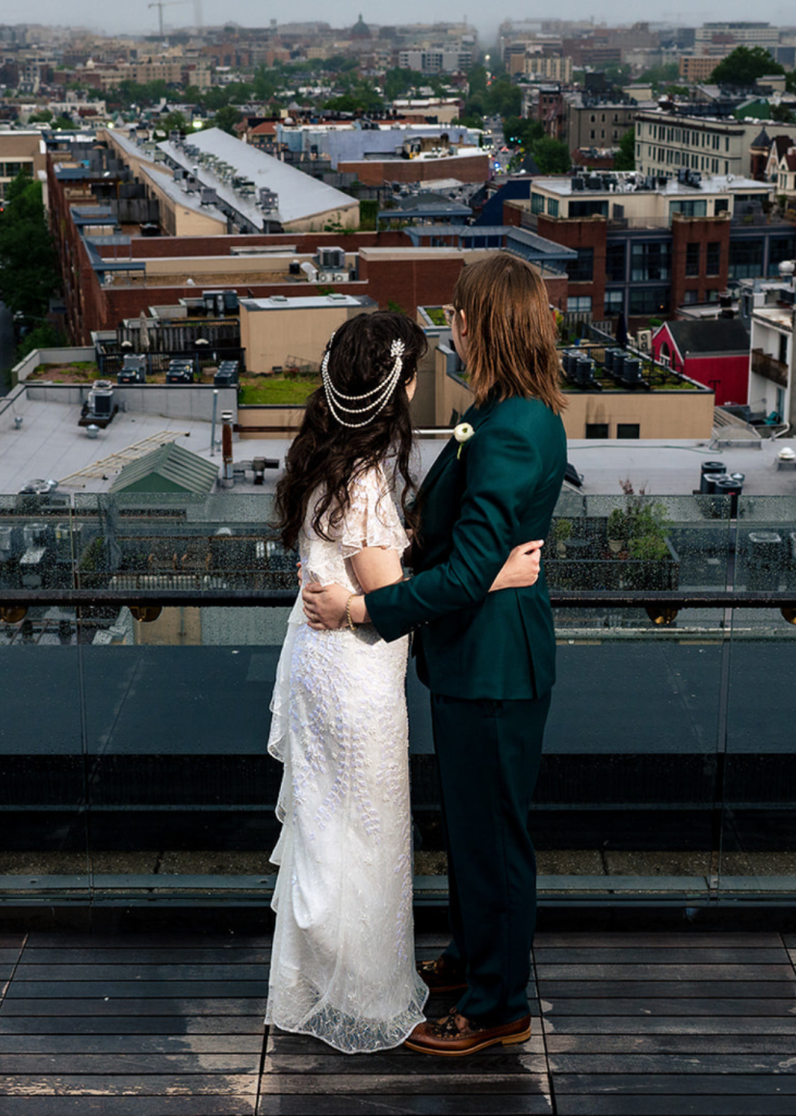 a couple looks out at the cityscape from the balcony at the line hotel