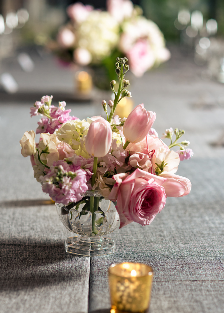 reception table centerpieces with pink flowers and votive candles