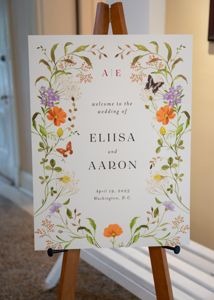 a wedding sign with the couple's name on it and decorative butterflies and flowers