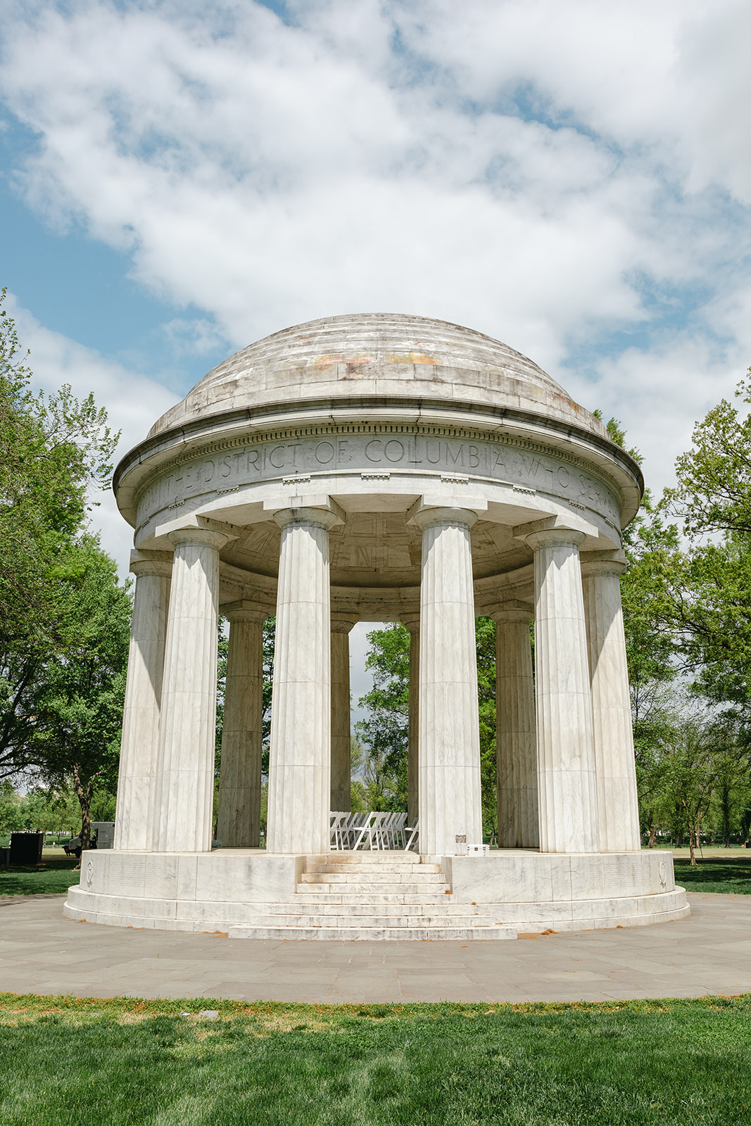 Washington, DC War Memorial wedding ceremony setup with white chairs arranged beneath the marble columns on the National Mall.