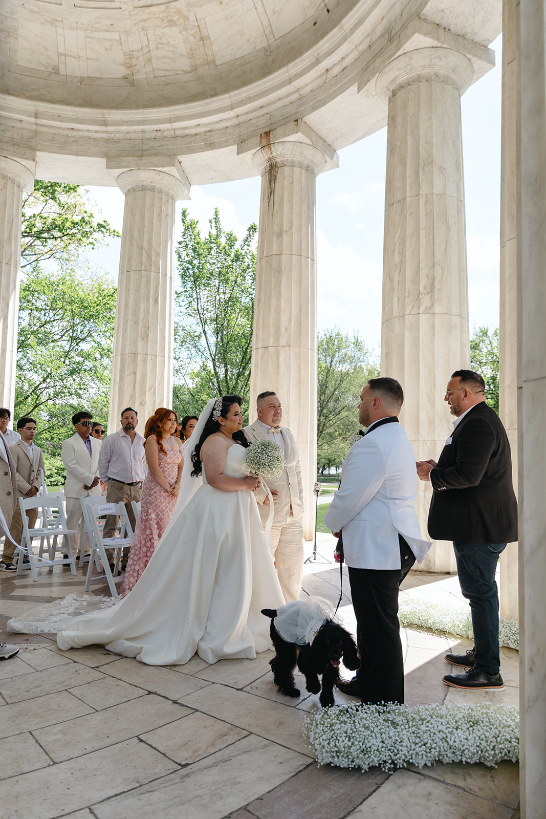 Washington, DC War Memorial wedding ceremony with the officiant talking and the couple at the front of the aisle with a groomsmen and dog