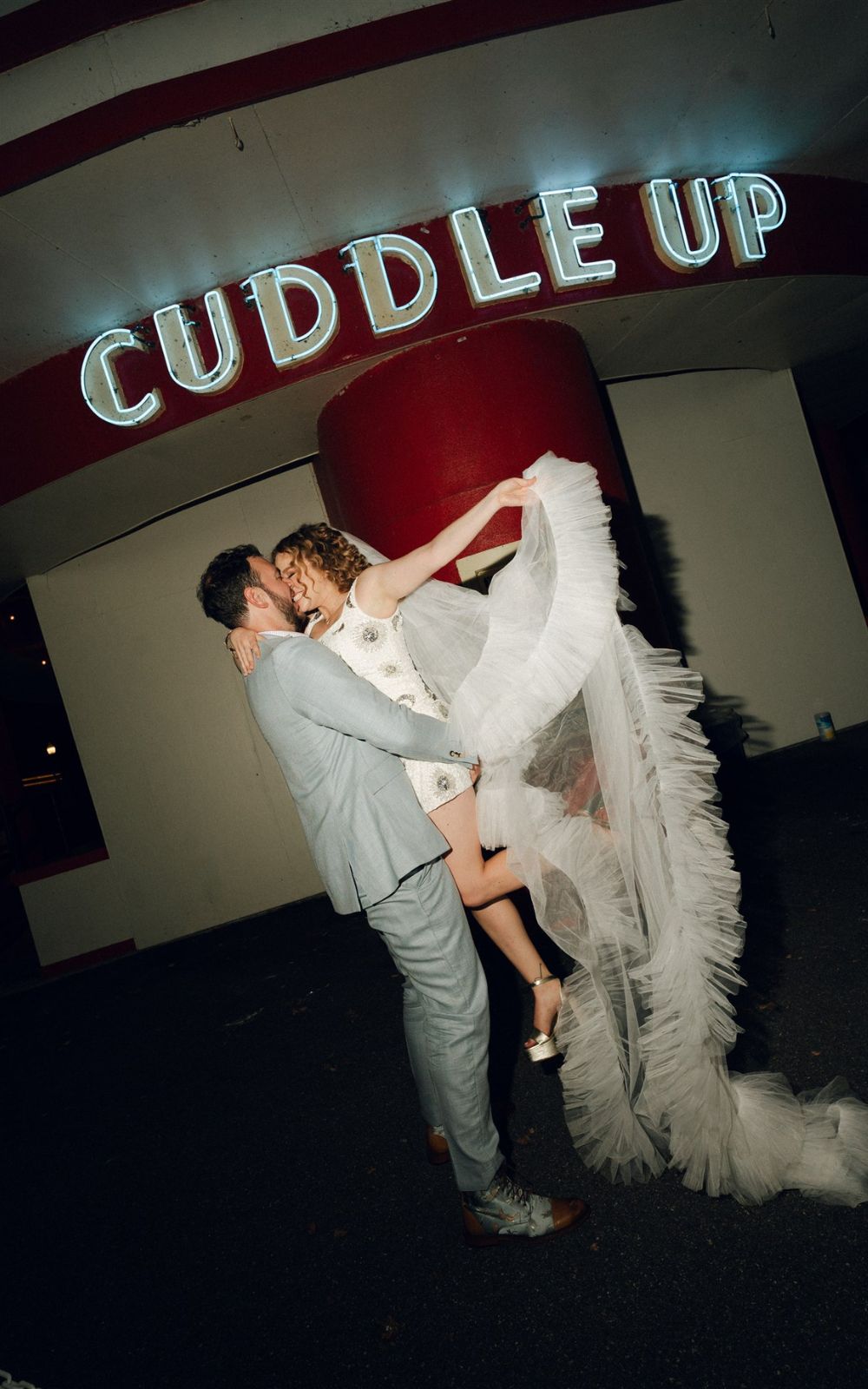 A bride and groom pose outside the Cuddle Up pavilion at Glen Echo Park in Maryland