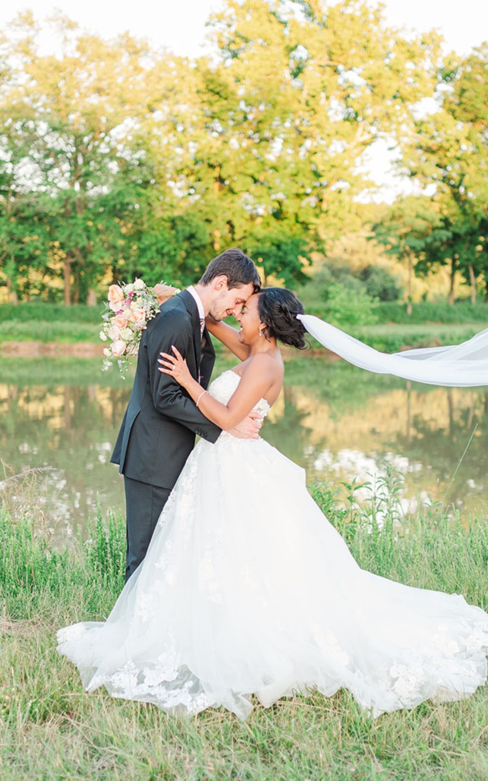 A bride and groom hold each other in a field at Riverside on the Potomac in Leesburg, VA