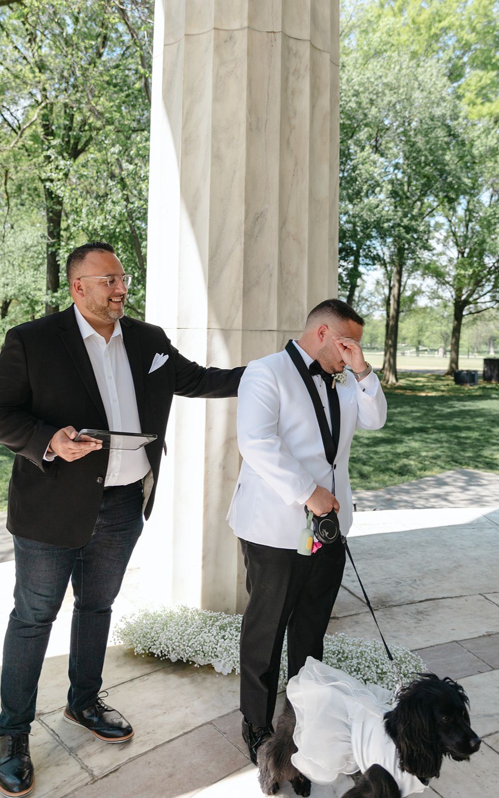 Groom stands with his dog at the DC War Memorial. The officiant places a comforting hand on his shoulder.