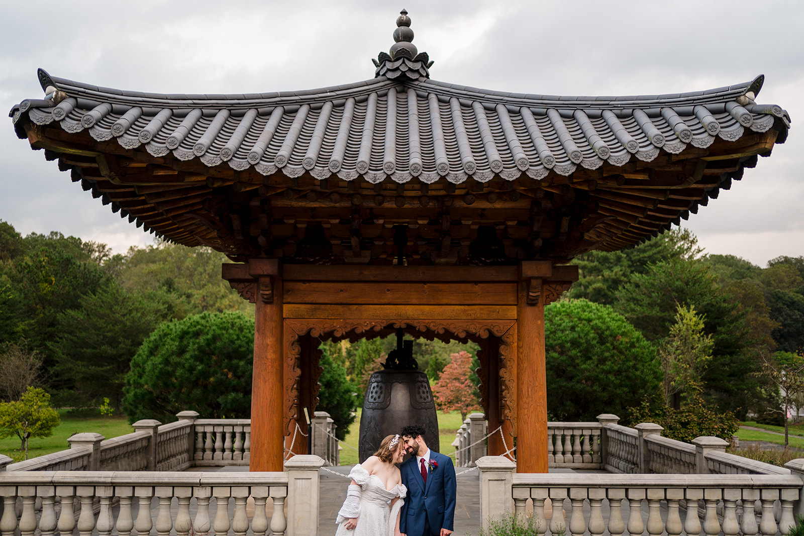 couple in garden leaning on one another in front of Koran Bell Garden
