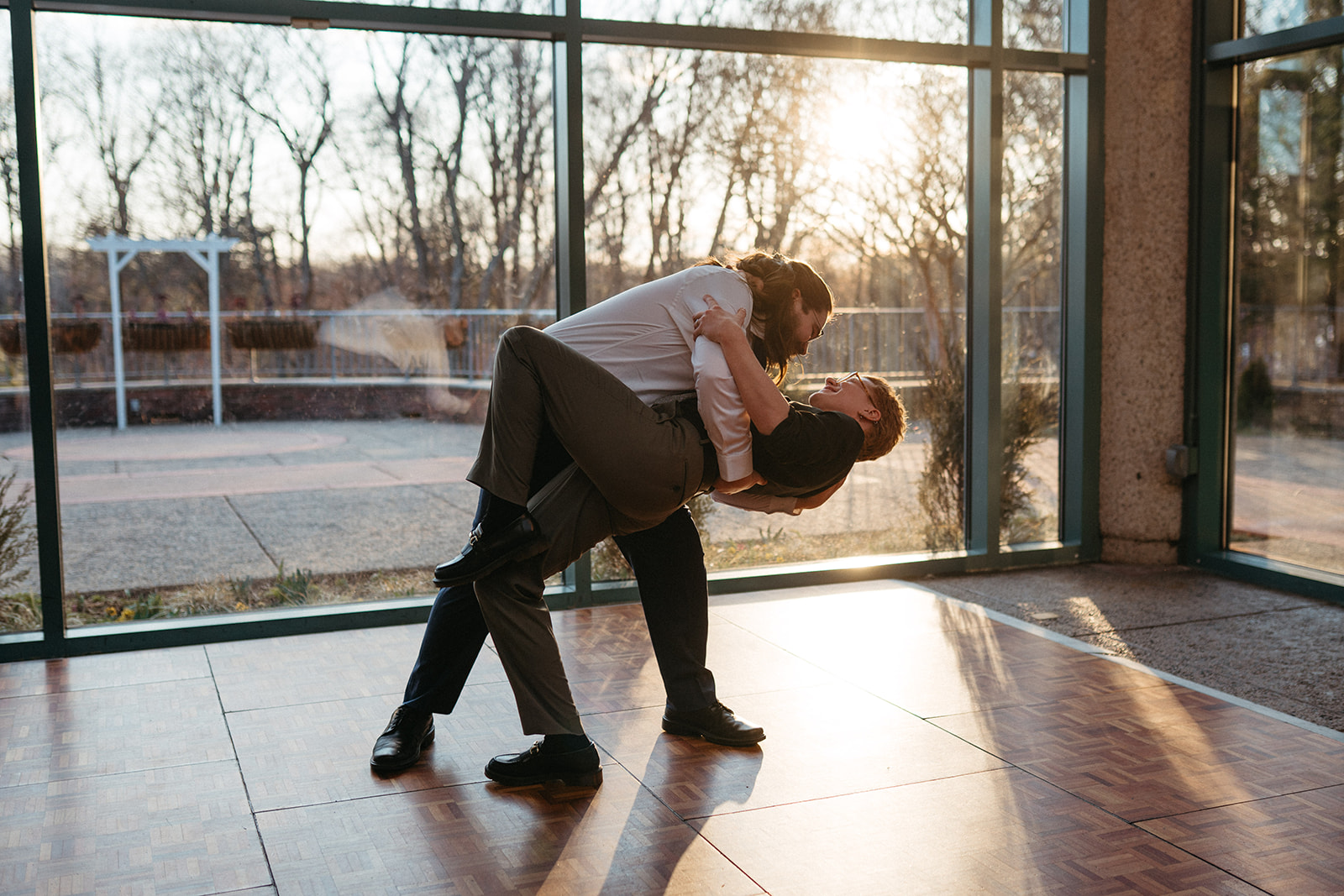 couple in front of windows being dipped at golden hour