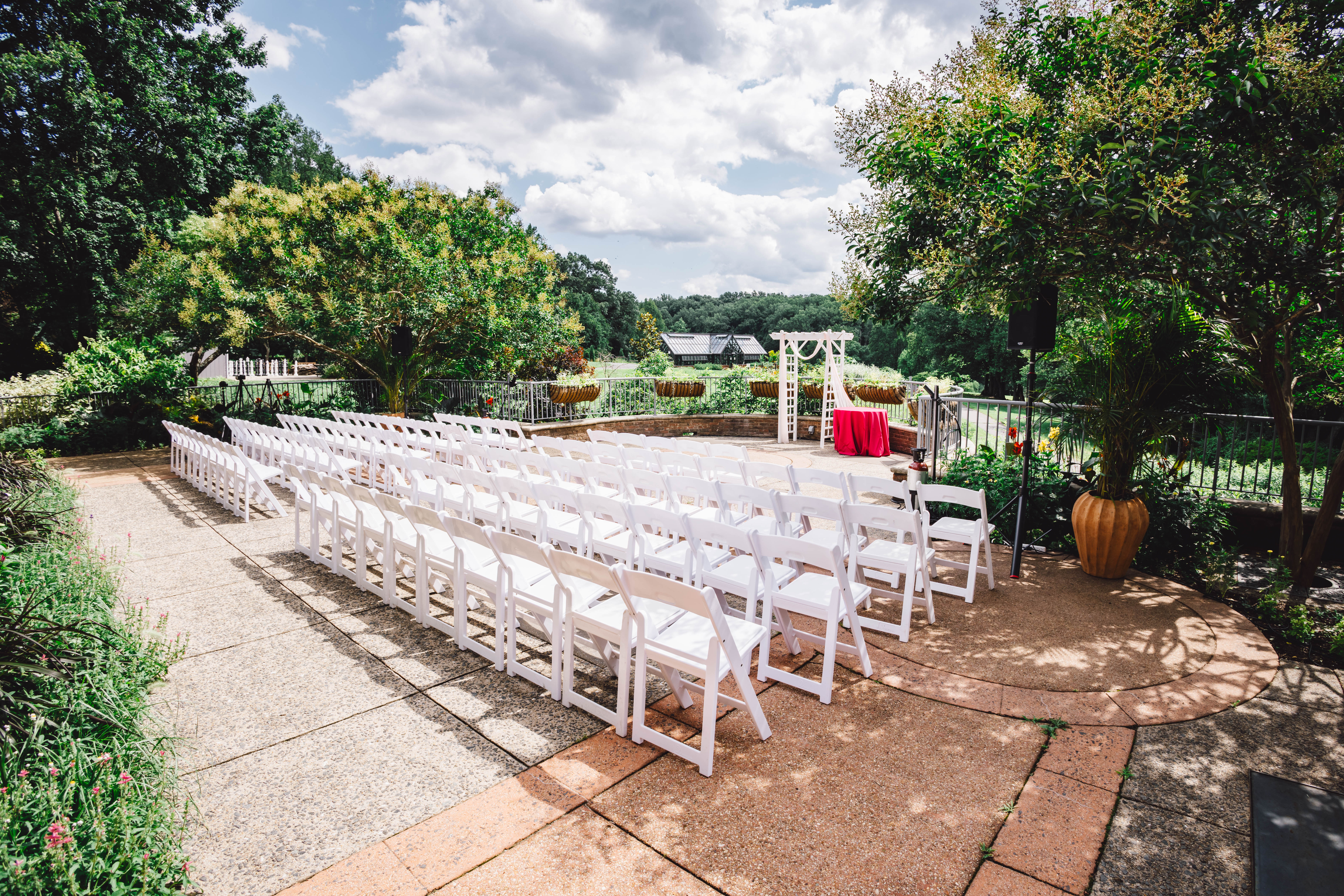 balcony with ceremony set up of white chairs and white arch at the end of aisle