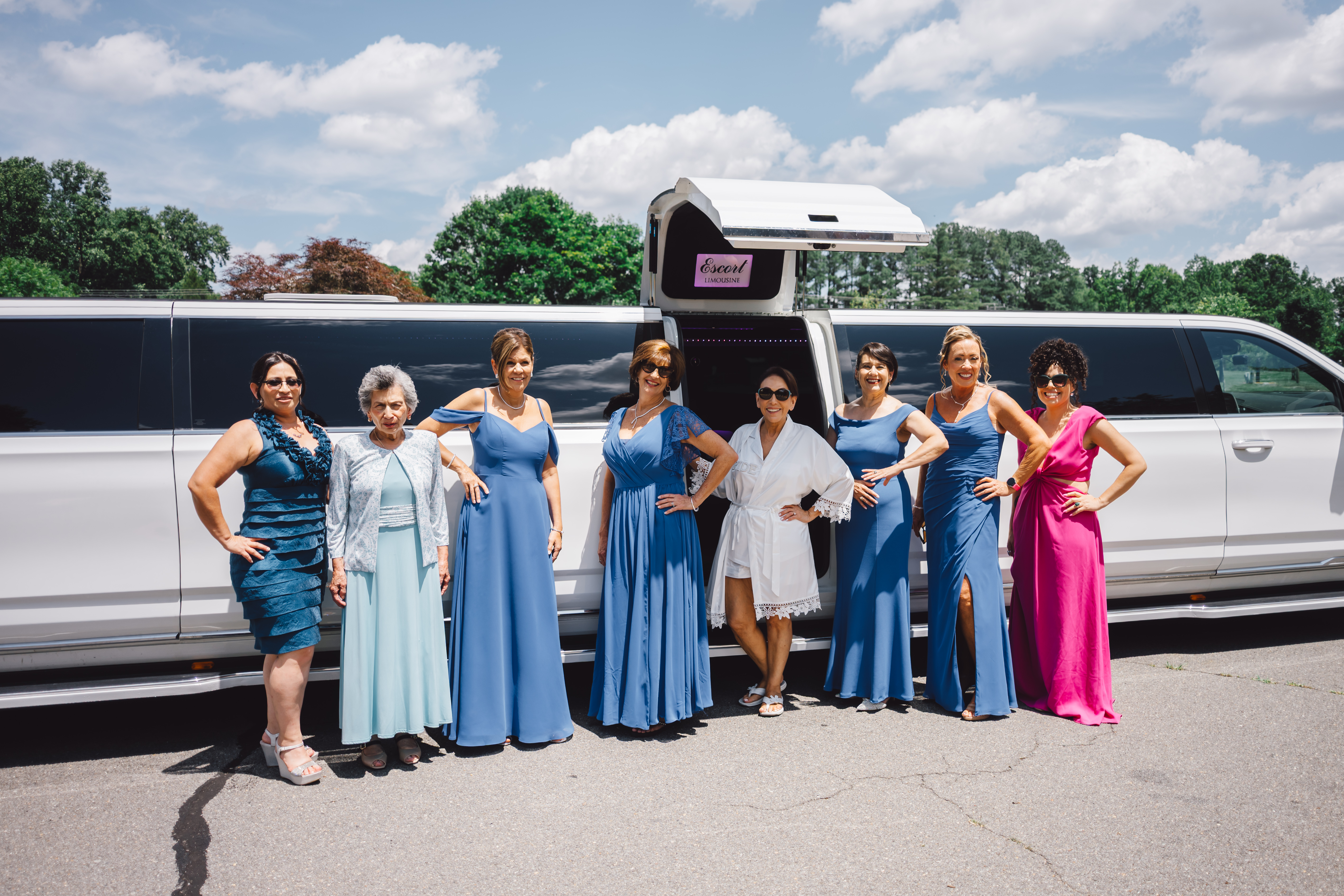 bridal party in front of white stretch limo