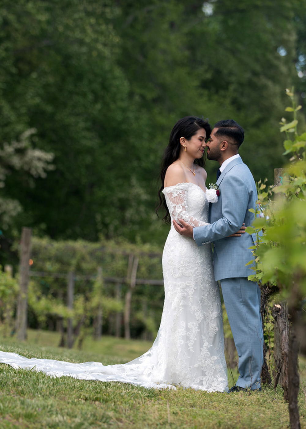 the wedding couple embraces among the vines outside Running Hare Vineyard