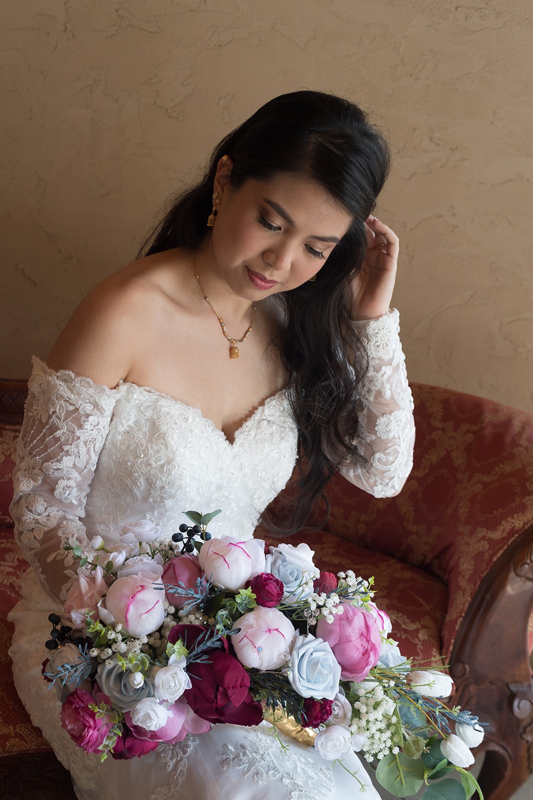 bride on chair looking a bouquet
