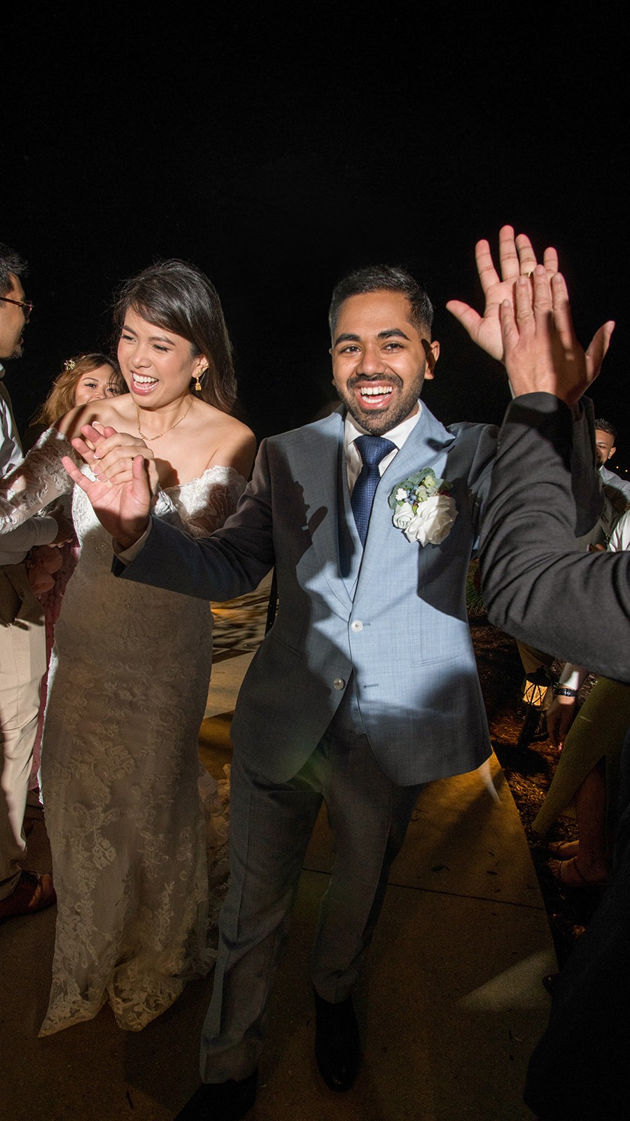 bride and groom walking pasts guests holding hands during exit