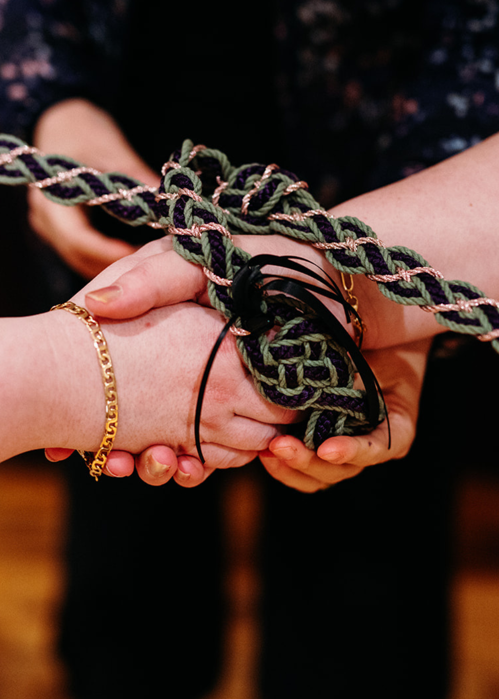 two hands joined by a handfasting cord during a marriage ceremony at Pinstripes Georgetown in Washington DC